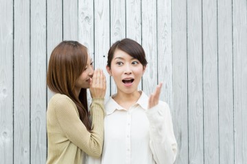 内緒話をする若い女性