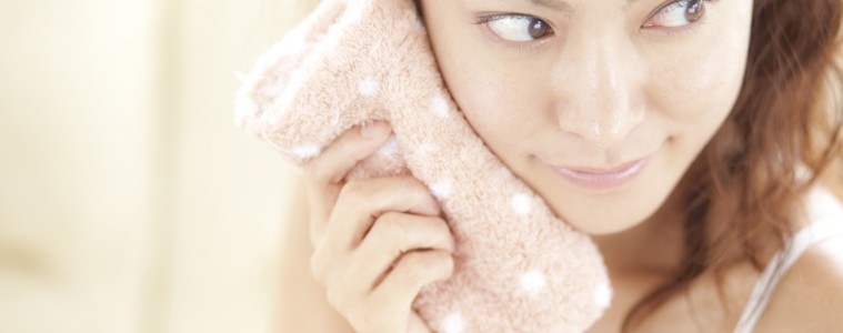 タオルで汗を拭く若い女性