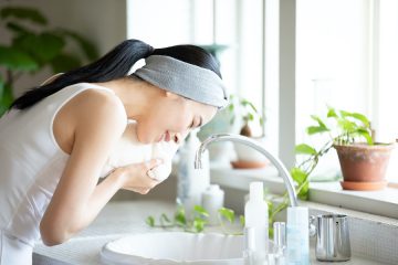 洗顔後にタオルで顔を拭く女性