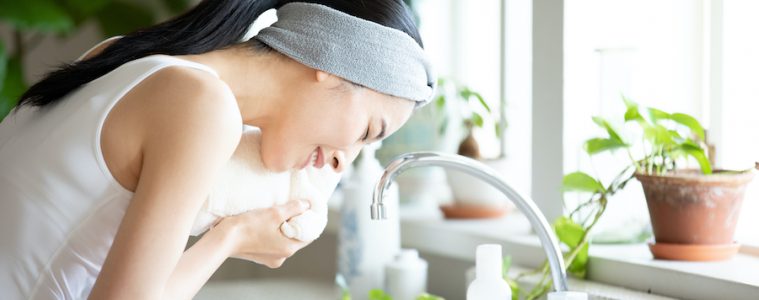 洗顔後にタオルで顔を拭く女性